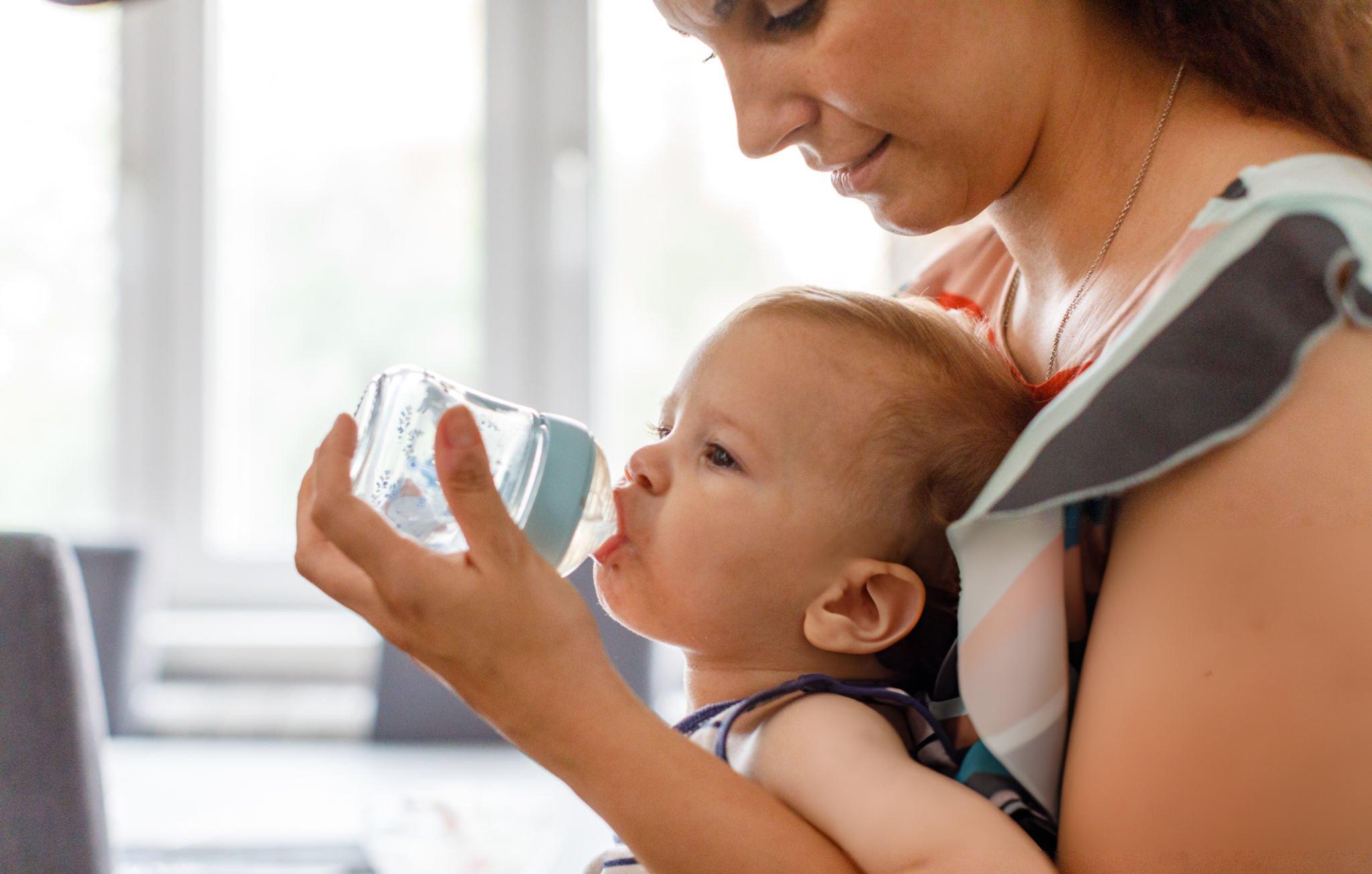 A young mother exercising in her home on an exercise bike - Postpartum Exercise